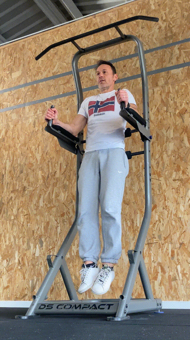sportif qui renforce ses abdominaux en montée de genoux croisés sur la chaise Romaine