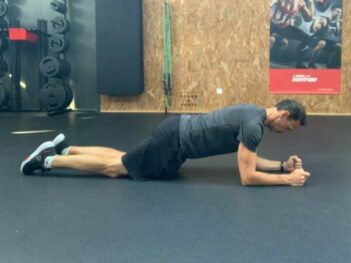 Homme en planche sur coudes et genoux